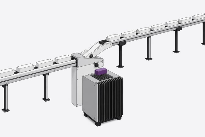 A mechanical routing junction directing solid blank blocks either directly into a local finned processing enclosure or onto a long, elevated transit rail for external processing.