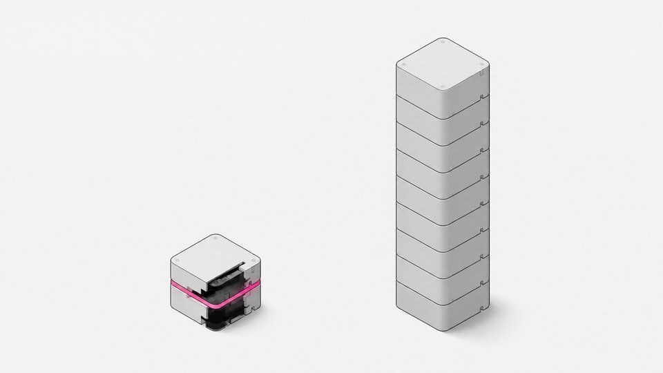 A small custom-built module stands next to a much taller stack of identical uniform blocks, illustrating a compact built tool versus a proliferating repeated system.