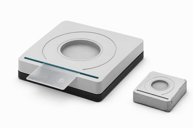 A precise scanning kiosk module with a card token passing through an accented scan-slit, next to a smaller, rougher duplicate module, representing the choice between buying and building an identity-verification system.