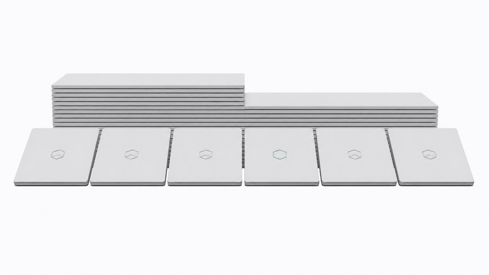 A line of nearly identical laptops with a chip-badge logo, where one laptop in the middle is missing its badge, illustrating Microsoft quietly dropping its Copilot+ PC branding.