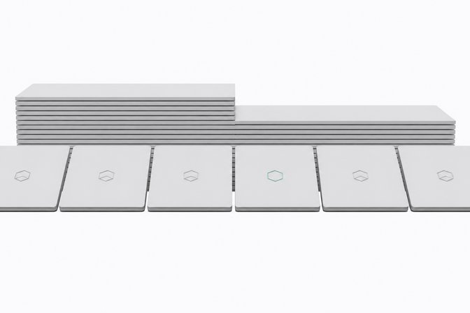 A line of nearly identical laptops with a chip-badge logo, where one laptop in the middle is missing its badge, illustrating Microsoft quietly dropping its Copilot+ PC branding.