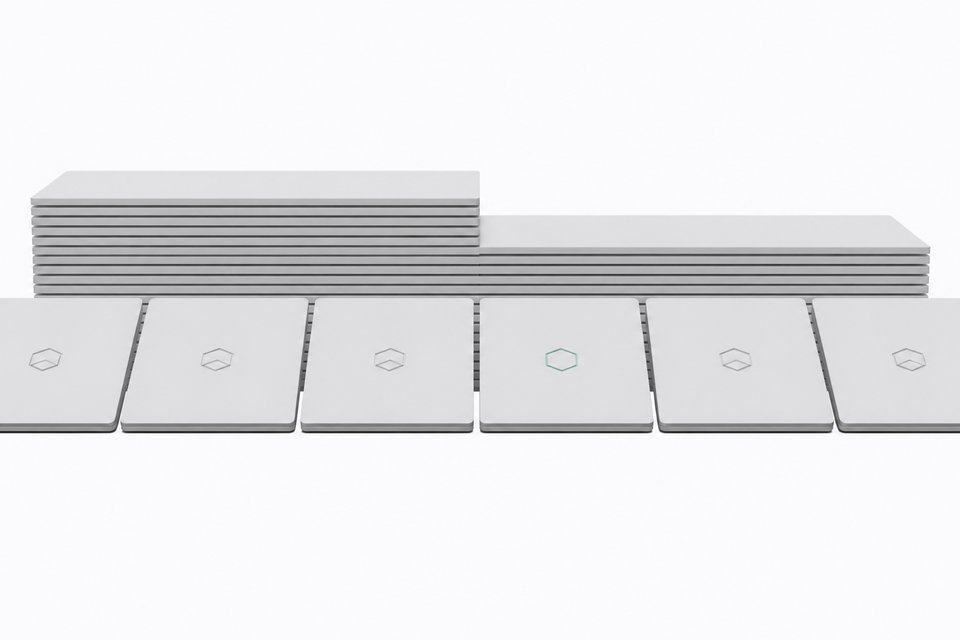 A line of nearly identical laptops with a chip-badge logo, where one laptop in the middle is missing its badge, illustrating Microsoft quietly dropping its Copilot+ PC branding.